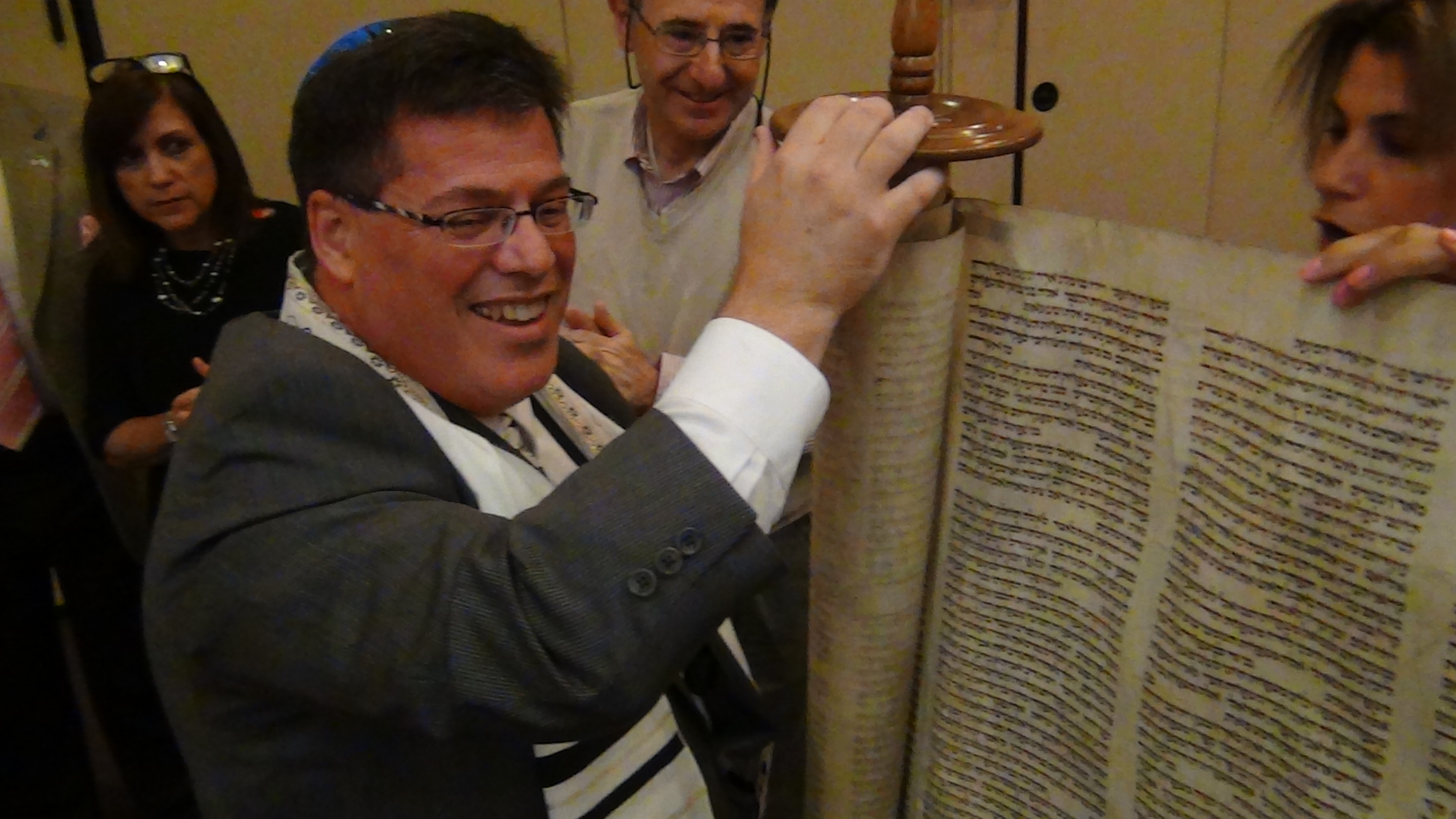 Cantor Neil Schnitzler unrolls a Holocaust surviving Torah scroll at Temple Emanuel