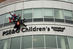 Window washers dressed as Batman and Spiderman rappel down the side of PSE&G Children's Hospital in New Brunswick, NJ